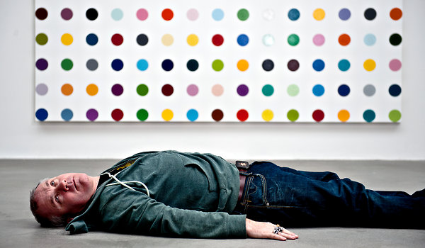 Damien Hirst in front of one of his spot paintings (that he probably didn't paint) in 2011.