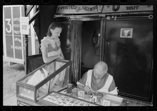 Wife of travelling photographer tinting small portraits, NAtional Rice Festival, Crowley, Louisiana. Russell Lee, October 1938. 